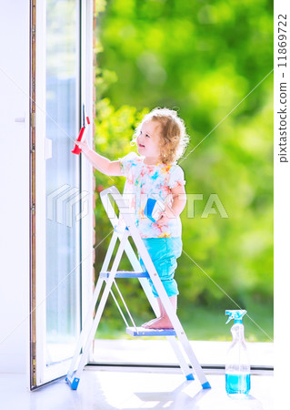 Little girl washing a window 11869722