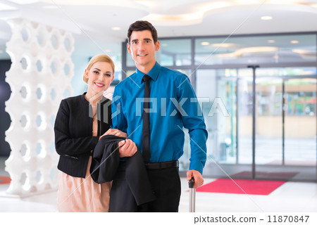 Man and woman arriving at hotel lobby with suitcase 11870847