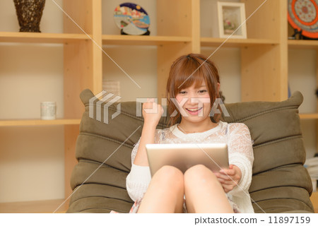 A woman who looks at a tablet PC and poses a guts 11897159