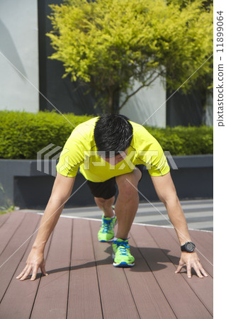 Asian man preparing to sprint Asian man preparing to sprint 11899064