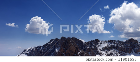 Panorama of snowy rocks and blue sky with clouds 11901653