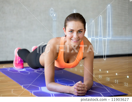 smiling woman doing exercises on mat in gym 11903627