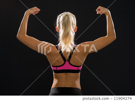 sporty woman from the back flexing her biceps sporty woman from the back flexing her biceps 11904274