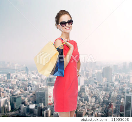 smiling elegant woman in dress with shopping bags smiling elegant woman in dress with shopping bags 11905098