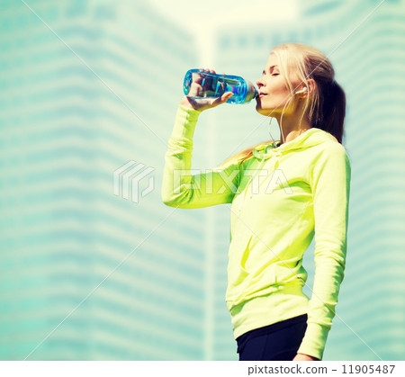 woman drinking water after doing sports outdoors woman drinking water after doing sports outdoors 11905487