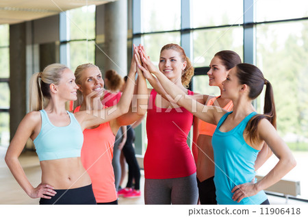 group of women making high five gesture in gym 11906418