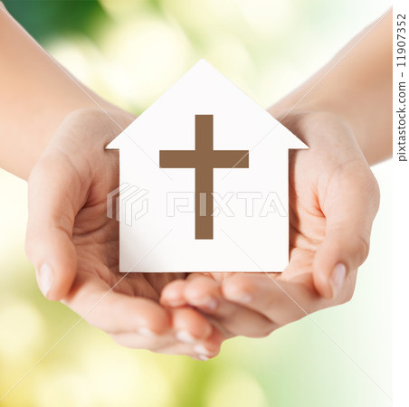 close up of hands and paper house with cross 11907352