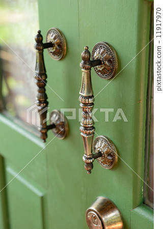 Door handle on green wooden door 11917970