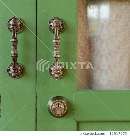 Door handle on green wooden door 11917975