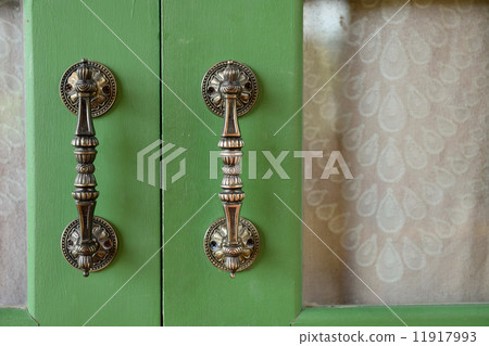 Door handle on green wooden door 11917993