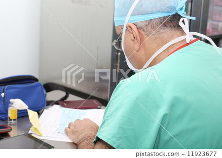 Surgeon writting report of the operation 11923677