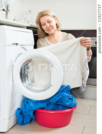 housewife looking at clothes near washing machine housewife looking at clothes near washing machine 11927737