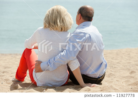 Mature lovers sitting on beach Mature lovers sitting on beach 11927778