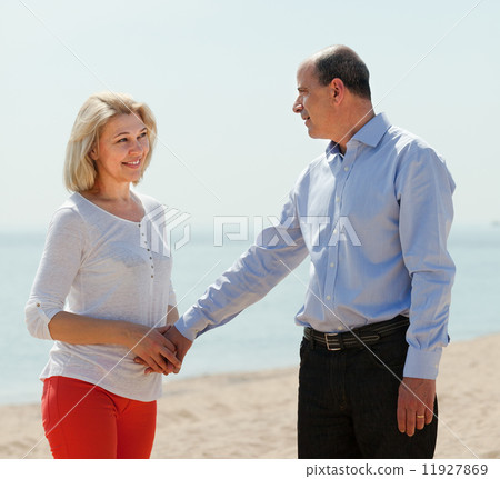 happy mature woman with man against sea happy mature woman with man against sea 11927869