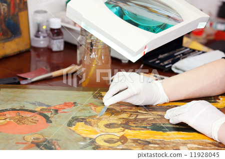Closeup of Restorer working on the old icon 11928045