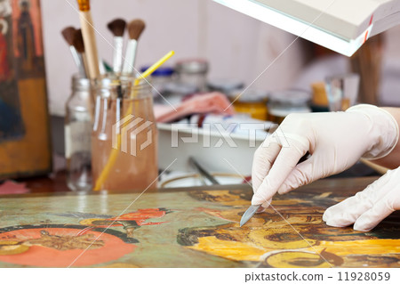 Restorer working on the ancient Christian icon 11928059