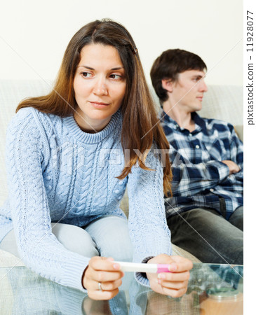 Sad woman with pregnancy test against boyfriend Sad woman with pregnancy test against boyfriend 11928077