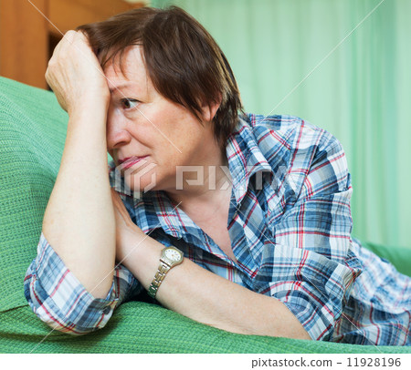 Stressed female pensioner on couch 11928196