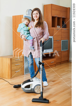 Woman cleaning living room with vacuum cleaner Woman cleaning living room with vacuum cleaner 11928309