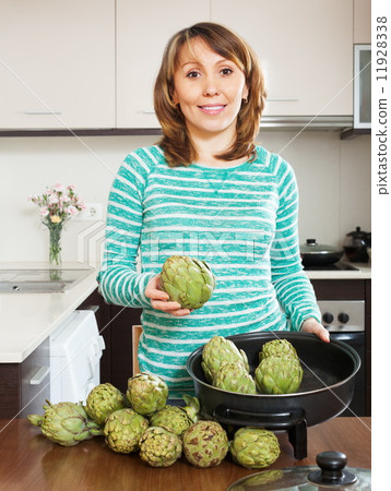 Happy woman cooking artichoke 11928338