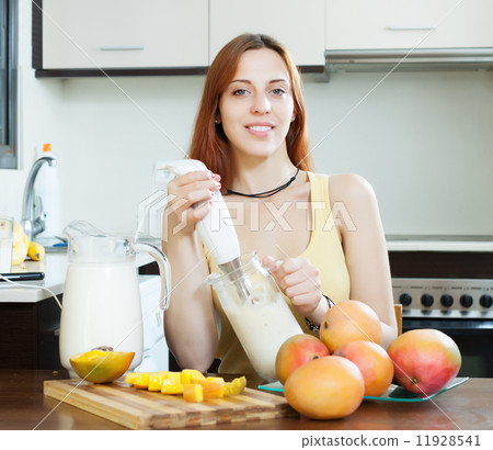woman making fresh milk beverages with blender from mango woman making fresh milk beverages with blender from mango 11928541