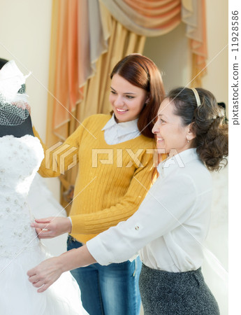 pretty bride chooses bridal dress at wedding store pretty bride chooses bridal dress at wedding store 11928586