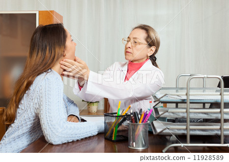 Doctor examines throat of young girl Doctor examines throat of young girl 11928589