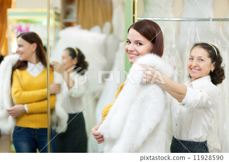 woman helps the bride in choosing fur cape woman helps the bride in choosing fur cape 11928590