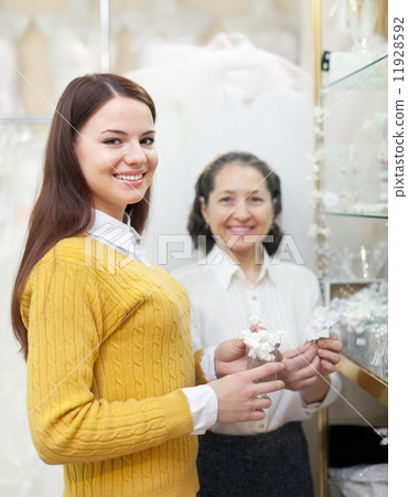 Girl chooses bridal accessories at wedding store Girl chooses bridal accessories at wedding store 11928592