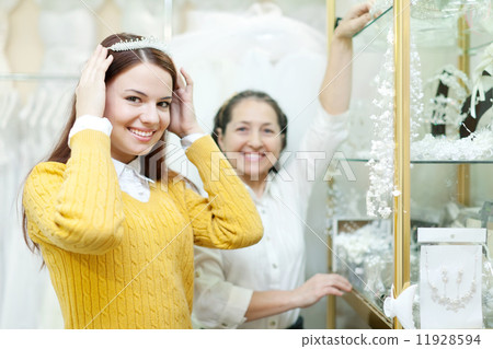 woman helps the bride in choosing bridal diadem woman helps the bride in choosing bridal diadem 11928594
