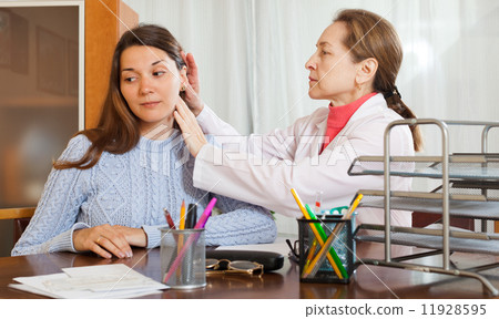 doctor examining ear of teenage girl doctor examining ear of teenage girl 11928595