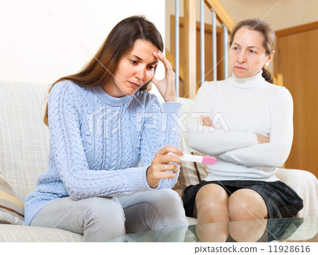 Sad woman looking at pregnancy test 11928616
