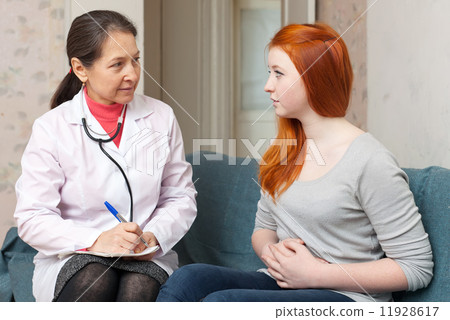 girl complaining to doctor about abdominal pain girl complaining to doctor about abdominal pain 11928617