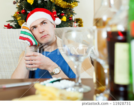 Man in red New Year hat stuping towel to head 11928731