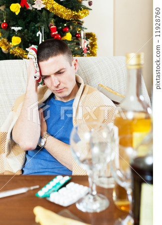 Suffering man with hangover with towel in hand 11928760