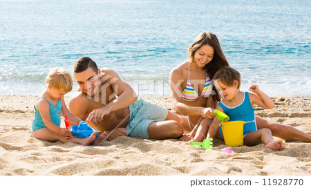 Family of four at the beach Family of four at the beach 11928770