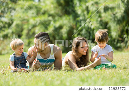 Parents with children laying in the grass Parents with children laying in the grass 11928772