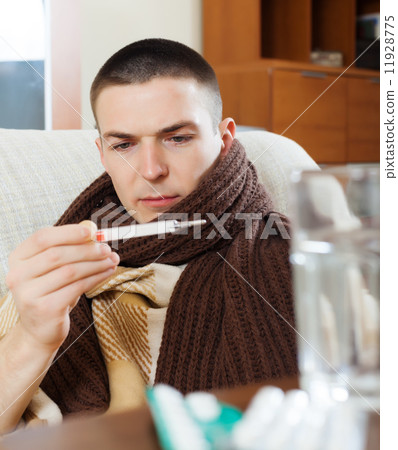 Sick ordinary man looking by thermometer Sick ordinary man looking by thermometer 11928775