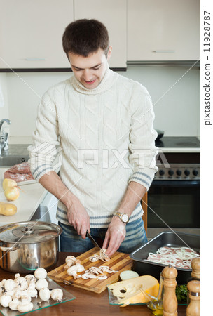 man cooking meat with mushrooms and potatoes 11928787
