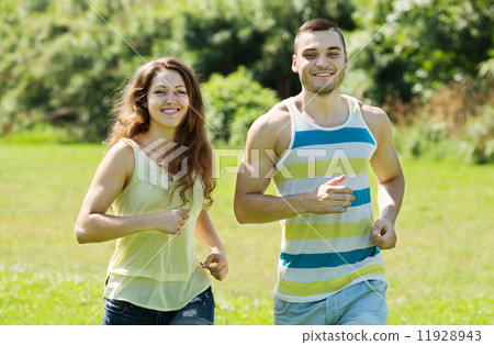 couple of joggers doing running at park and smiling couple of joggers doing running at park and smiling 11928943