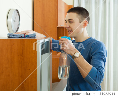 man cleaning glass in living room 11928944