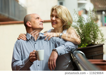 Couple drinking coffee at balcony Couple drinking coffee at balcony 11929064