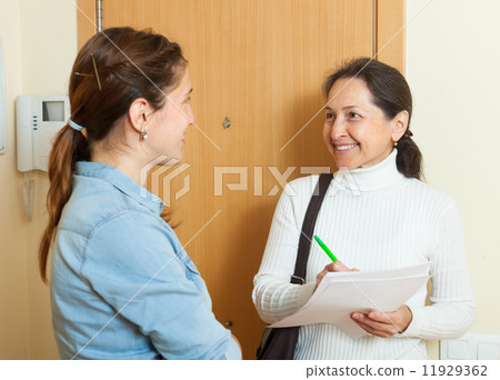 woman answer questions of mature woman with papers woman answer questions of mature woman with papers 11929362