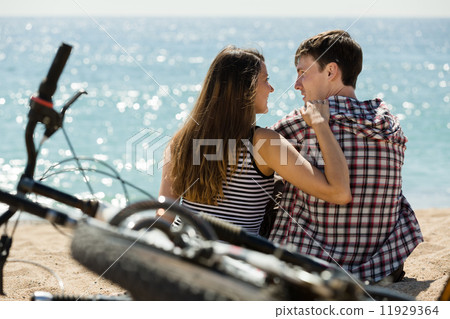 girl and her boyfriend on beach near bikes girl and her boyfriend on beach near bikes 11929364