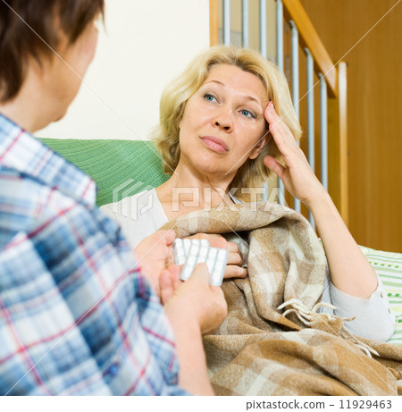 Two aged women with pill on couch 11929463