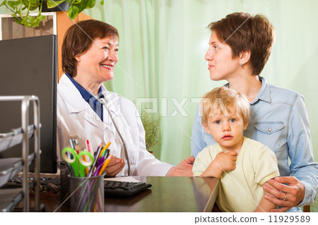 mother with baby talking with doctor at clinic 11929589