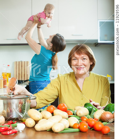 women of three generations in domestic kitchen women of three generations in domestic kitchen 11929596