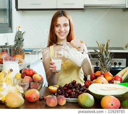 Happy woman pouring milk cocktail with fruits 11929785