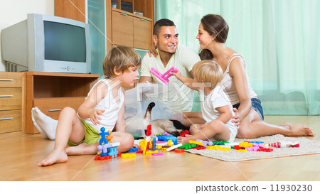 Family of four at home with toys Family of four at home with toys 11930230