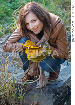 Attractive autumn woman and falling leaves 11933423